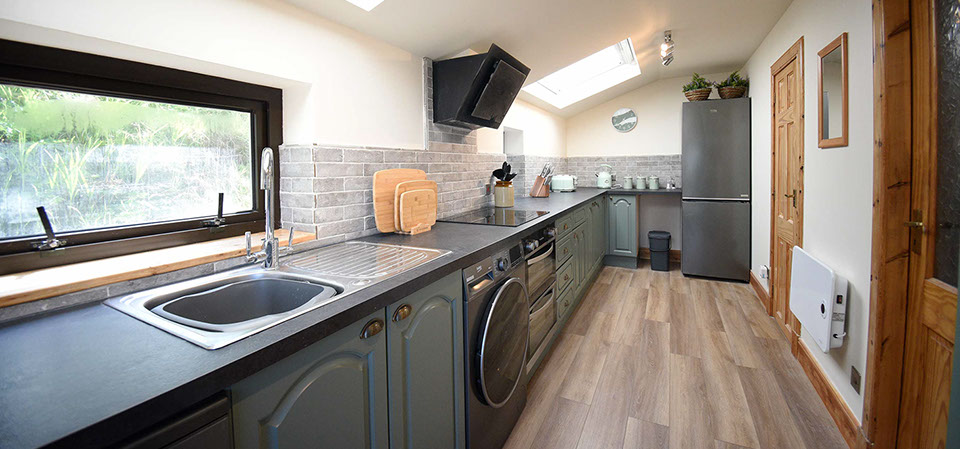 Caberfeidh Boat House contains a modern kitchen with washing machine oven hob fridge freezer kettle and microwave