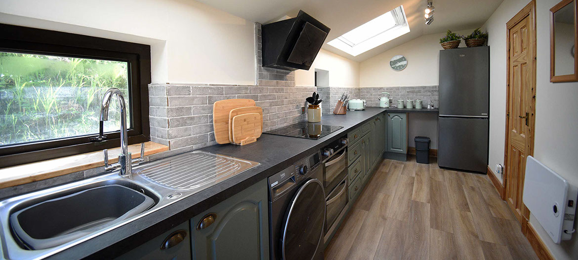 Caberfeidh Boat House self catering accommodation contains a spacious kitchen with oven hob microwave and fridge freezer