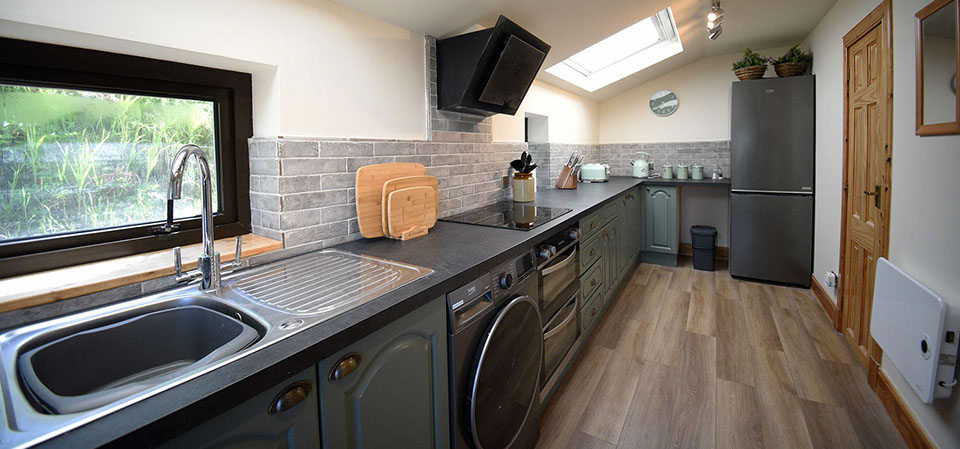 Caberfeidh Boat House self catering accommodation contains a spacious kitchen with oven hob microwave and fridge freezer